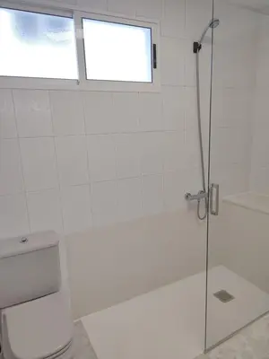 a bathroom with a shower and a toilet and a window at Apartamento vacacional Meira in Meira