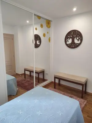 a bedroom with a mirror and a bed and benches at Apartamento vacacional Meira in Meira