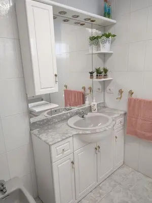 a white bathroom with a sink and a mirror at Apartamento vacacional Meira in Meira