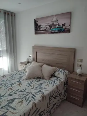 a bedroom with a bed and a picture on the wall at Apartamento vacacional Meira in Meira