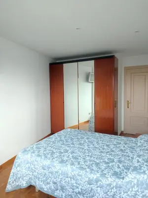 a bedroom with a bed with a blue comforter at Apartamento vacacional Meira in Meira