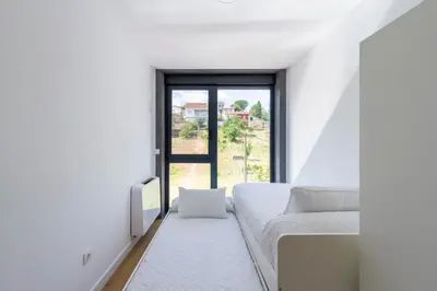 a white room with a couch and a window at Urbanfive apartamentos Ourense centro in Ourense