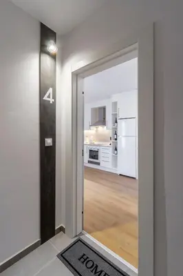 a door leading to a kitchen with white appliances at Urbanfive apartamentos Ourense centro in Ourense