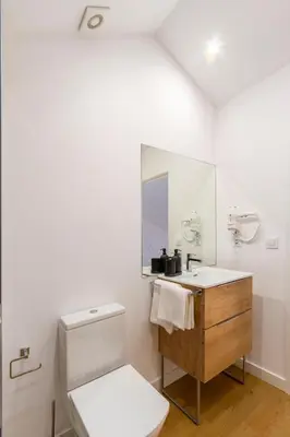 a white bathroom with a toilet and a sink at Urbanfive apartamentos Ourense centro in Ourense
