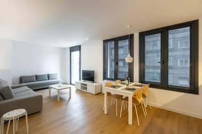 a living room with a table and a couch at Urbanfive apartamentos Ourense centro in Ourense