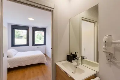 a bathroom with a mirror and a bed and a sink at Urbanfive apartamentos Ourense centro in Ourense