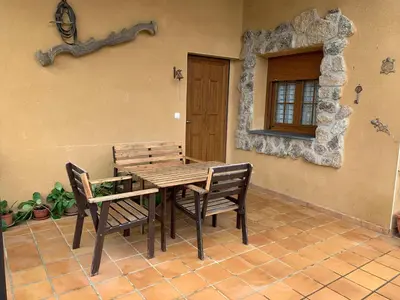 a wooden table and chairs on a patio at Estrella del alba in Villarino de Sanabria