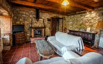 a living room with a couch and a fireplace at Mirador de Babia in Huergas
