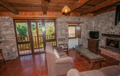 a living room with a couch and a fireplace at Mirador de Babia in Huergas