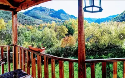 a screened in porch with a view of the mountains at Mirador de Babia in Huergas