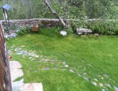 a yard with a bench and a stone wall at Mirador de Babia in Huergas