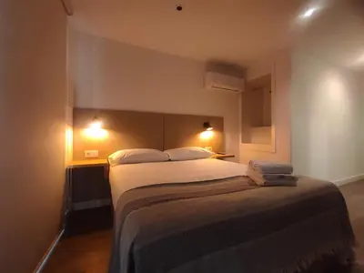 a bedroom with a large bed with two lights on it at L1 - Disfruta en Os Vinos a dos pasos de la catedral in Ourense