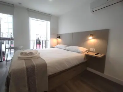 a bedroom with a large bed with towels on it at L1 - Disfruta en Os Vinos a dos pasos de la catedral in Ourense