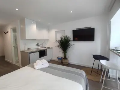 a white room with a bed and a kitchen at L1 - Disfruta en Os Vinos a dos pasos de la catedral in Ourense