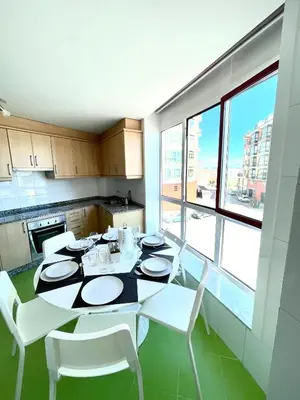 a dining room with a table and white chairs in a kitchen at Trailhouse CASTELAO in Sarria
