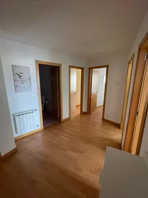an empty living room with wooden floors and doors at Trailhouse CASTELAO in Sarria