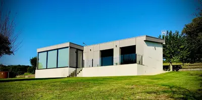 a white building with windows on a grass field at Casa Areas in Boimorto