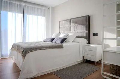 a white bedroom with a large bed and a window at Casa Areas in Boimorto