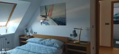 a bedroom with a bed and a picture of a boat at Descubre Foz con nosotros in Foz