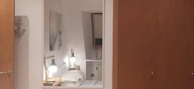a white room with a mirror and a white couch at Descubre Foz con nosotros in Foz