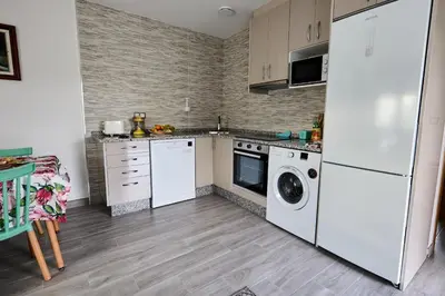 a kitchen with a white refrigerator and a dishwasher at Casa Melina in Villapedre
