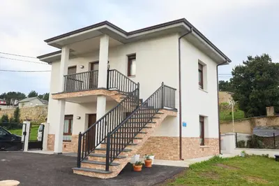 a white house with a staircase in front of it at Casa Melina in Villapedre