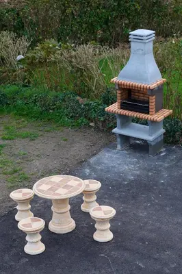 a table and two stools in front of a grill at Casa Melina in Villapedre