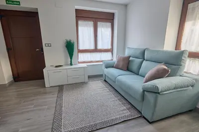 a living room with a blue couch and a window at Casa Melina in Villapedre