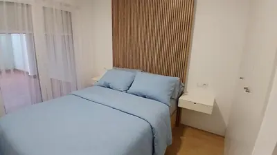 a bedroom with a bed with blue sheets and a window at Floor en Forcarei in Forcarei