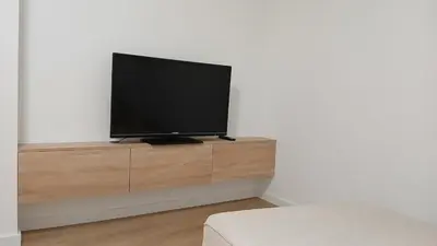 a flat screen tv sitting on top of a wooden entertainment center at Floor en Forcarei in Forcarei