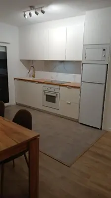 a kitchen with white cabinets and a sink and a table at Floor en Forcarei in Forcarei
