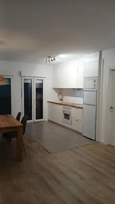 a kitchen with white cabinets and a table and chairs at Floor en Forcarei in Forcarei