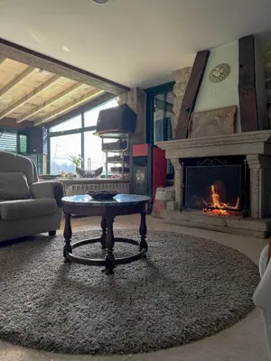 a living room with a fireplace and a table at Hotel rústico Aldea Figueiredo in Ourense
