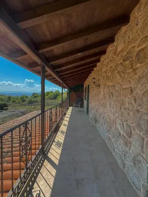 a building with a stone wall and a walkway at Hotel rústico Aldea Figueiredo in Ourense