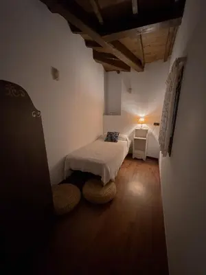 a small bedroom with a bed and a table at Hotel rústico Aldea Figueiredo in Ourense