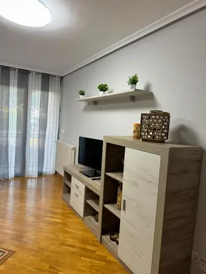 a living room with a television and a wooden cabinet at Paseo del río in Ponferrada