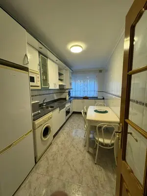 a kitchen with a table and a sink and a dishwasher at Paseo del río in Ponferrada