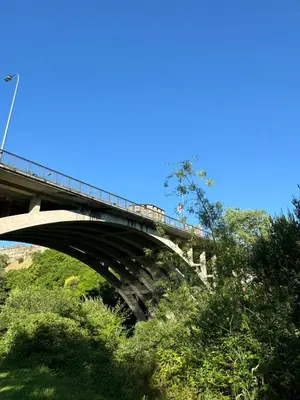 a bridge over a hill with a blue sky at Paseo del río in Ponferrada