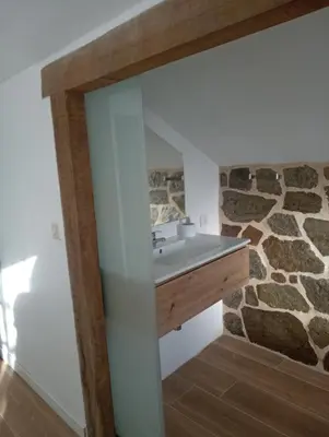 a bathroom with a sink and a stone wall at El Naranjo in Padrón