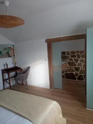 a bedroom with a bed and a table and a mirror at El Naranjo in Padrón