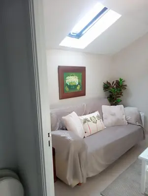 a couch in a living room with a skylight at El Naranjo in Padrón