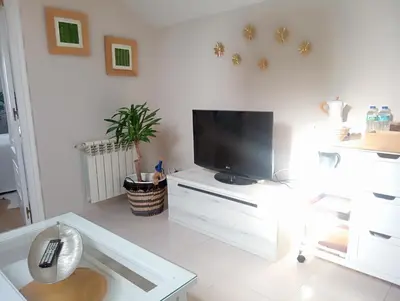 a living room with a tv on a white cabinet at El Naranjo in Padrón