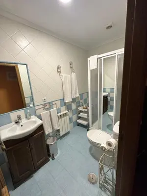 a bathroom with a sink and a toilet and a mirror at Apartamentos Helenias in Boal