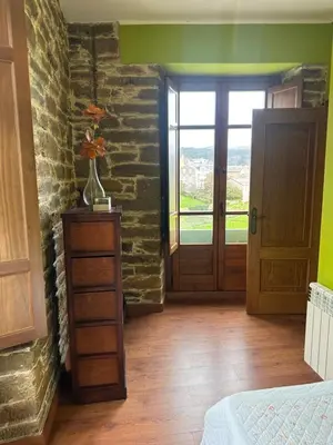 a bedroom with green walls and a door with a window at Apartamentos Helenias in Boal