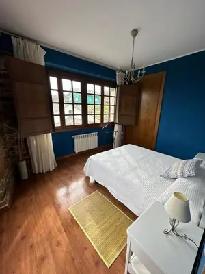 a bedroom with a white bed and blue walls at Apartamentos Helenias in Boal