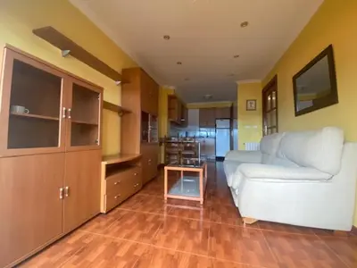 a living room with a white couch and a kitchen at Monte Faro in Lalín