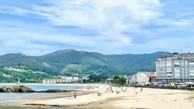 a group of people on a beach near the water at The Cliffs - AT Seiramar Os Castelos in Viveiro
