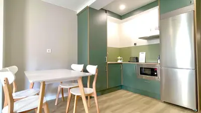 a kitchen with a table and chairs and a refrigerator at The Cliffs - AT Seiramar Os Castelos in Viveiro