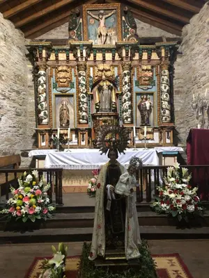 a church with a statue in front of a altar at Casa Cantadora in Ambasmestas