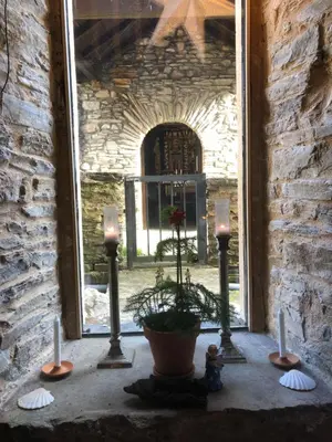 a window with three candles and a potted plant at Casa Cantadora in Ambasmestas
